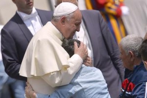 Pope Francis hugs a young boy after his general audience at St Peter'