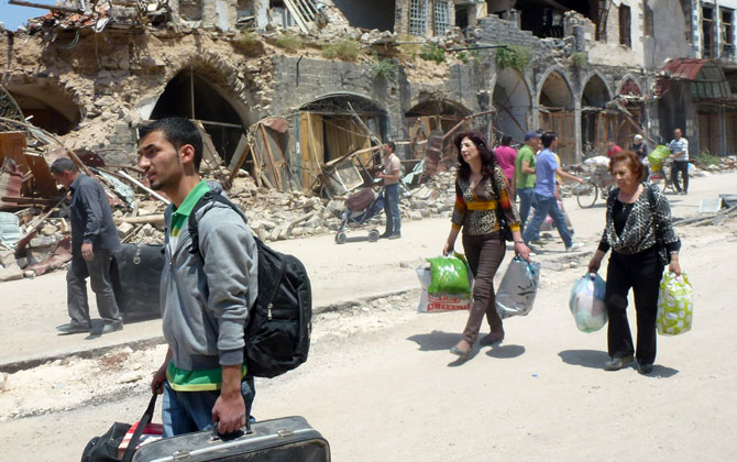 Civiles sirios regresan a una Homs en ruinas.