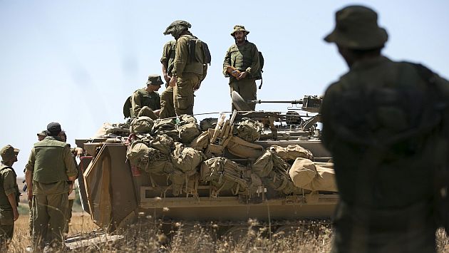Reservistas del ejército israelí se colocan encima de un transporte blindado de personal (APC por sus siglas en inglés) fuera del centro de la Franja de Gaza.