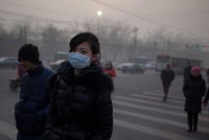 A woman wearing a mask crosses a road during severe pollution in Beij