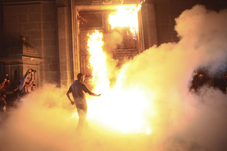 Manifestantes incendiando la puerta del Palacio Nacional mexicano / Sásheka Gutierrez (EFE)