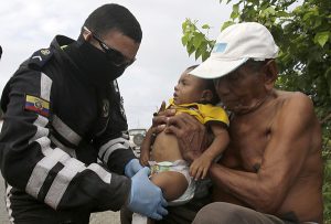 A highway police doctor checks on a baby who's family was affected by the 7.8-magnitude earthquake that hit Ecuador's Pacific coast, at a road side in Canaveral, Ecuador, Thursday, April 21, 2016. President Rafael Correa said Ecuador's worst earthquake in decades caused billions of dollars of damage and he is raising sales taxes and putting a one-time levy on millionaires to help pay for reconstruction. (AP Photo/Dolores Ochoa) -----