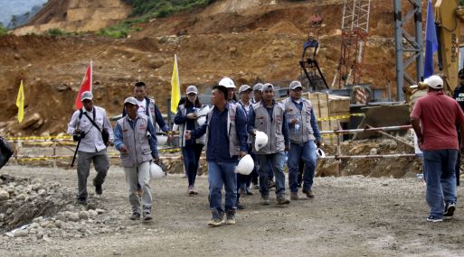 Chinese and Ecuadorean workers walk by during a ceremony marking the start of construction of a mine owned by Chinese mining company EcuaCorriente in el Pangui